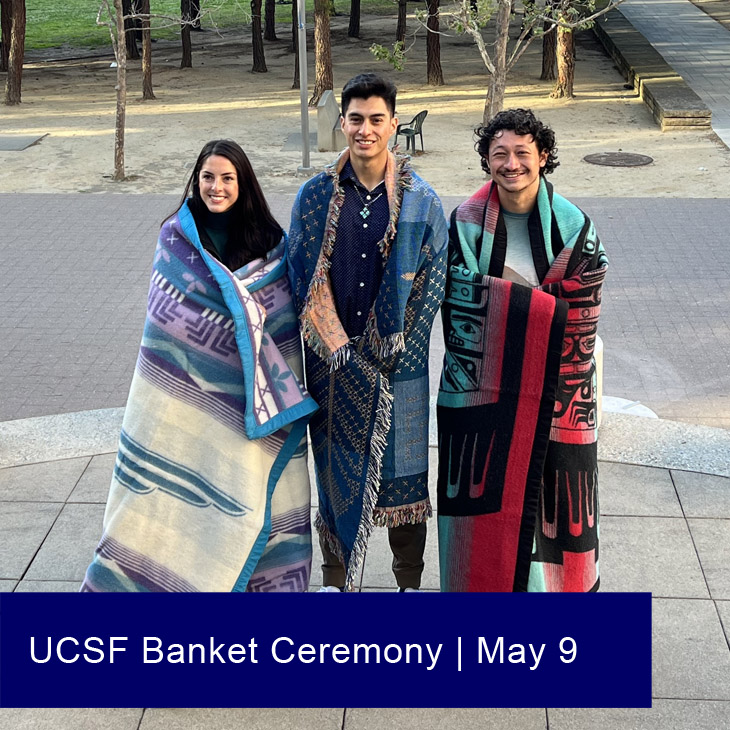 Three graduating Indigenous American Indian students, each wearing a colorful blanket, attend the 2023 UCSF Blanket Ceremony.